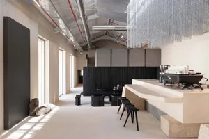 A modern living and dining space with a large window, counter, and dining table, featuring a predominantly white color scheme and minimalist design