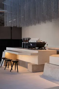 A dimly lit bar with a marble counter and a black coffee machine, creating a cozy and inviting atmosphere