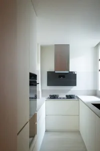 Modern kitchen with white cabinets, a black stove, and natural light from a window above the stove