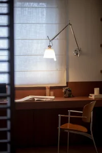 A study or workspace with a wooden desk, chair, lamp, and books, creating a warm and inviting atmosphere