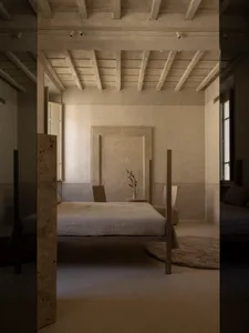 Cozy bedroom with a stone wall, wooden floor, a bed, and a chair near a window, dimly lit
