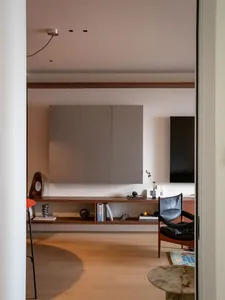 Cozy modern living space with a wooden floor, comfortable furniture, and natural light from a window