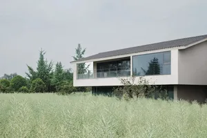 A modern house with a white exterior, surrounded by a lush green field, featuring a large deck and clean lines, with natural light streaming through the windows