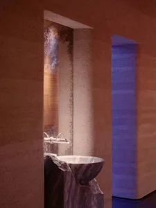 Bathroom with a sink and toilet in a dimly lit space with a stone-like appearance