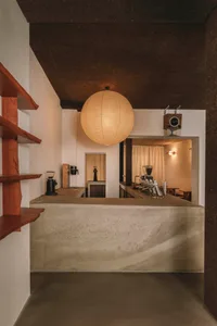 Modern kitchen with a concrete counter, sink, and various appliances, with a lived-in atmosphere