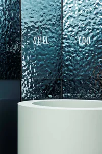 A modern bathroom with a white sink and a prominent blue wall, well-lit and clean