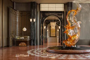 Large modern building lobby with a glass sculpture of a number two, black and white color scheme, and natural light from windows