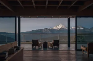 溫馨客廳，有兩張沙發、一張餐桌和一盆植物，特大窗戶享有壯麗山景