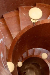 A curved marble staircase in a soft, diffused light, creating a warm and elegant atmosphere