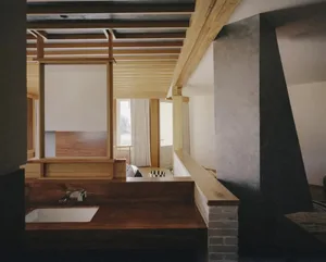 Bathroom with a sink under a window, a wooden bench, and natural light from the window