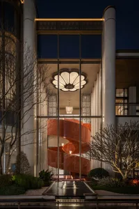 A modern building with a prominent red marble staircase, set against a dimly lit background