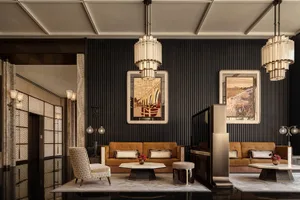 A dimly lit living room with a metal chandelier, a couch, a chair, and a dining table in a black and white color scheme