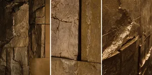 A stone wall with rough, textured stone, illuminated by natural light from different angles