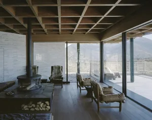 A well-lit living room with a wooden floor, a fireplace, a couch, and a chair, creating a warm and inviting atmosphere