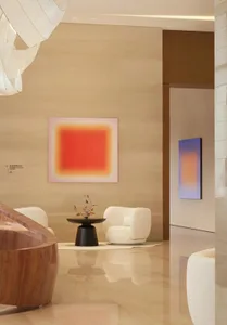 一間採光充足的客廳，採用現代設計，設有大窗、沙發、椅、餐桌及花瓶，呈現乾淨簡約風格