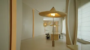 Large, empty dining room with a white color scheme, a dining table, and chairs, illuminated by natural light