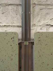 A stone wall with a metal bar attached to it, set against a warm and inviting background with natural light