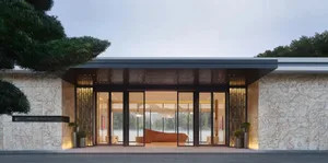 現代客廳空間，擁有大型玻璃牆、自然光線、沙發與單椅，营造溫暖且親切的氛圍