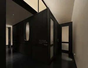 A dimly lit bathroom with a toilet and doorway leading to a hallway