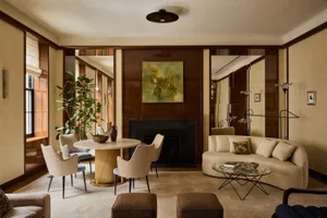 Cozy living room with a fireplace, couch, chair, dining table, and decorative items, giving a warm and inviting atmosphere