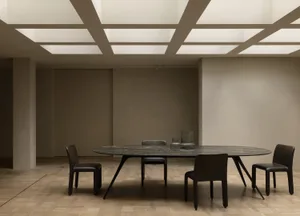 A dimly lit dining room with a large wooden table and marble top, surrounded by black chairs