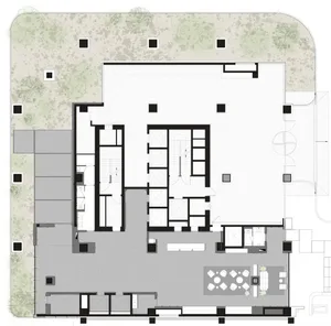 A modern open space with white walls, chairs, and dining tables, with natural light from windows
