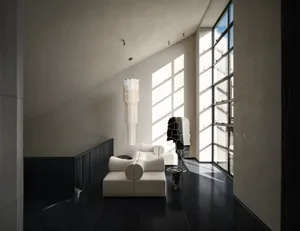 Dimly lit living room with a white couch and chair, large window, and modern simplicity