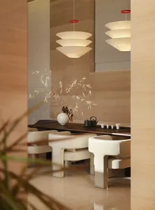 A well-lit restaurant with a wooden table and chairs, surrounded by a vase, in a modern and elegant setting