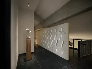A dimly lit hallway with white walls and a wooden pole, creating a mysterious atmosphere with clean lines and minimalistic design