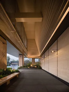 A sleek and contemporary lobby with a glass and wood exterior, featuring a bench and plenty of natural light