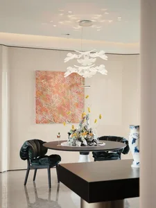 A dimly lit dining room with a black table and chairs, surrounded by a vase, in a modern space with a mix of wood and metal materials