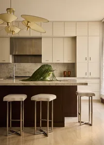 Modern kitchen with a marble countertop, stools, and a large window allowing natural light to enter the space