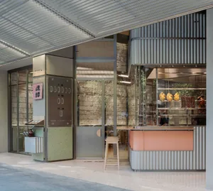 Modern restaurant with a large window, wood and metal elements, and a variety of seating options