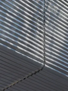A photograph of a building with a visible crack in the metal wall near the top, suggesting potential damage or structural issues
