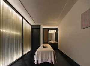 Cozy bedroom with a bed, a mirror, and a table, featuring modern design elements and clean lines
