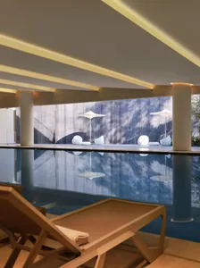 A blue tiled pool area with patio furniture and umbrellas, creating a relaxing outdoor space