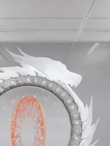 A white dragon statue in a room with a ceiling, illuminated by a lighting system, creating a dramatic effect