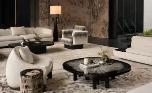 Cozy living space with a black and white color scheme, featuring a rug, couch, chair, coffee table, vase, and potted plant, with dim lighting creating an intimate atmosphere
