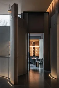 A well-lit dining space with a large window, a dining table, and a sink, featuring predominantly white materials and a sleek, contemporary style