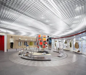 現代零售店內中央設有圓形展示區，周圍陳列服裝商品，搭配明亮燈光，营造溫馨氛圍