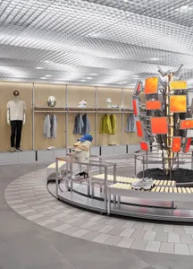 A well-lit shoe store with a colorful display of shoes in the center, surrounded by shelves and racks, and natural light coming in through the windows