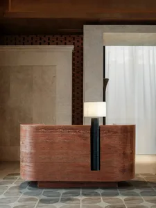 Modern bathroom with a red marble countertop, white curtain, bathtub, and sink in a dimly lit space