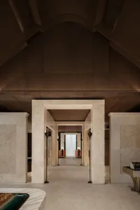 Luxurious living room with marble flooring and walls, soft warm lighting, and comfortable furniture