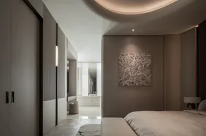 A calm and inviting bedroom with a grey bed, white walls, a mirror, and a painting on the wall