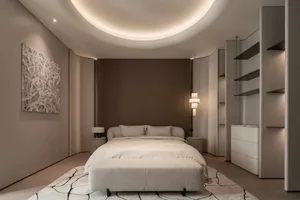Cozy bedroom with a bed, a couch, and a lamp, featuring a white color scheme and soft warm lighting