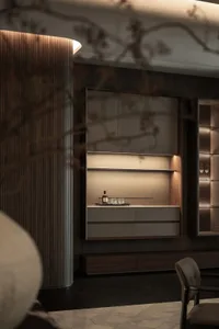 A modern kitchen with a wooden cabinet, glass door, and a countertop with a bottle and two cups