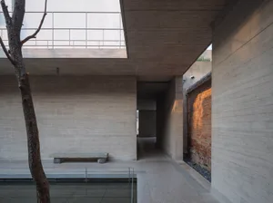 Large modern building with a concrete facade, open space, high ceiling, and natural light