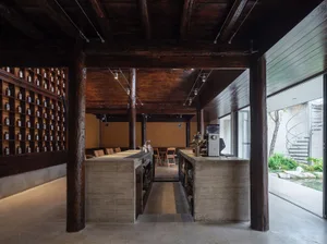 Warm and inviting restaurant with a wooden interior, featuring a bar area, dining tables, and natural lighting