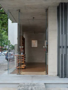 A modern room with a large open space, concrete floor, and a glass door, showcasing its architectural features and design elements