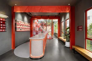 A well-lit restaurant with a metal counter, a red roof, and a welcoming atmosphere
